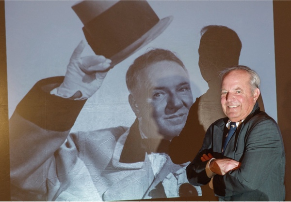 Ron standing next to a projected image on screen of his grandfather.
